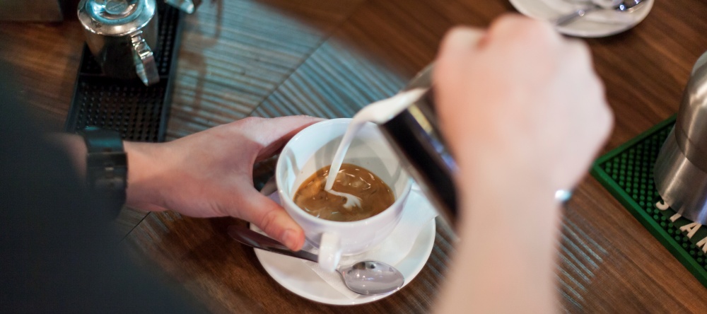 crop-barista-making-nice-latte-1000x600