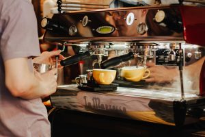 coffee shop worker prepares the coffee on the espresso machine