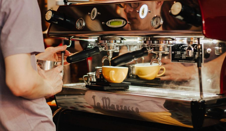 coffee shop worker prepares the coffee on the espresso machine