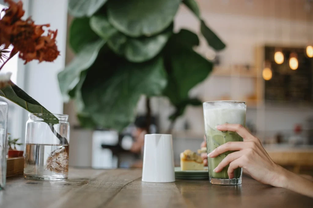 Osoba drži čašu ohladjene ledene Matcha Latte