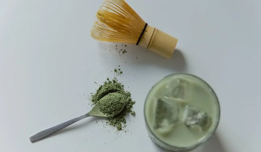 Matcha prah na stolu pored čaše Matcha latte